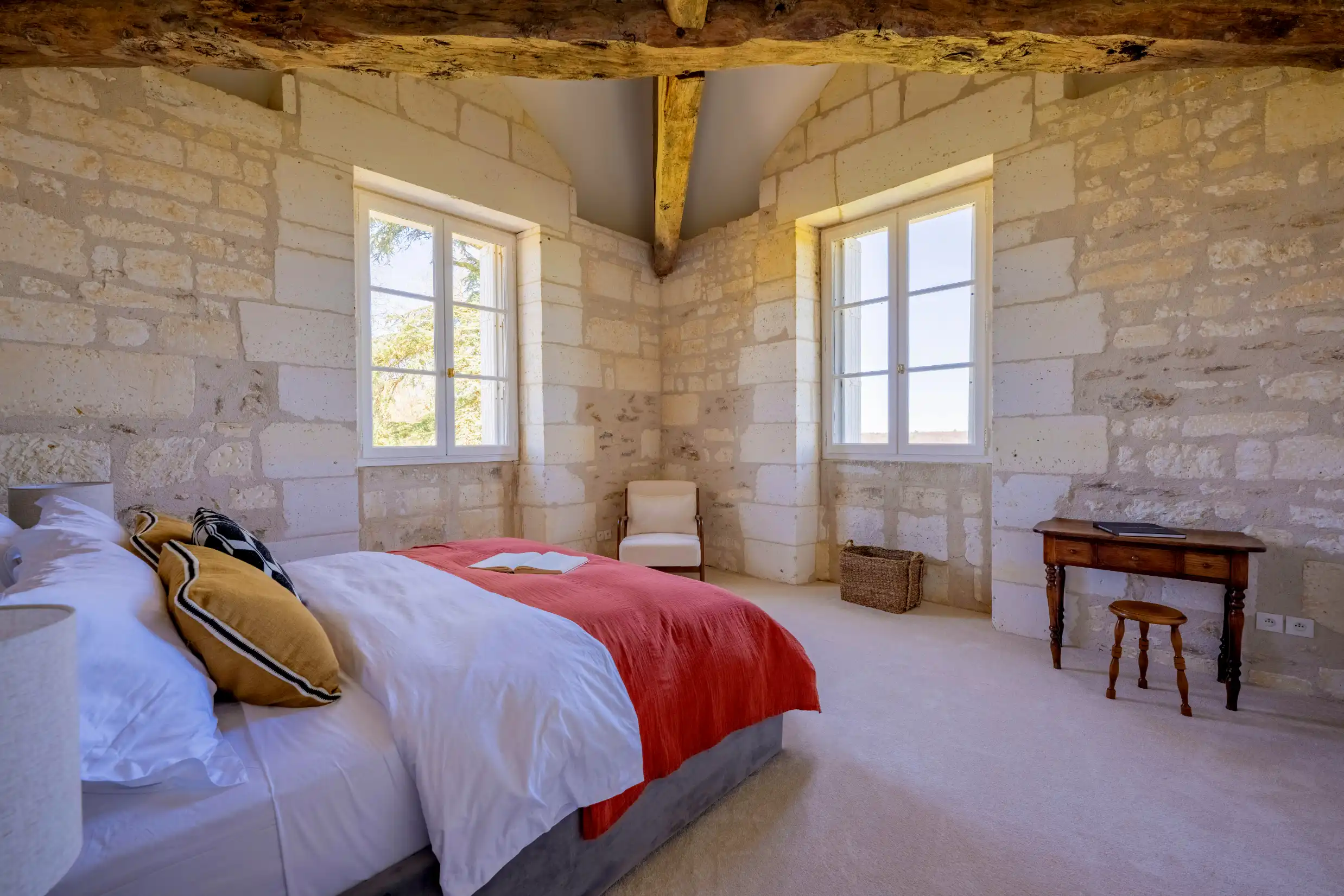 The Commonwealth room with a king-size bed, antique cabinet, and elegant decor.