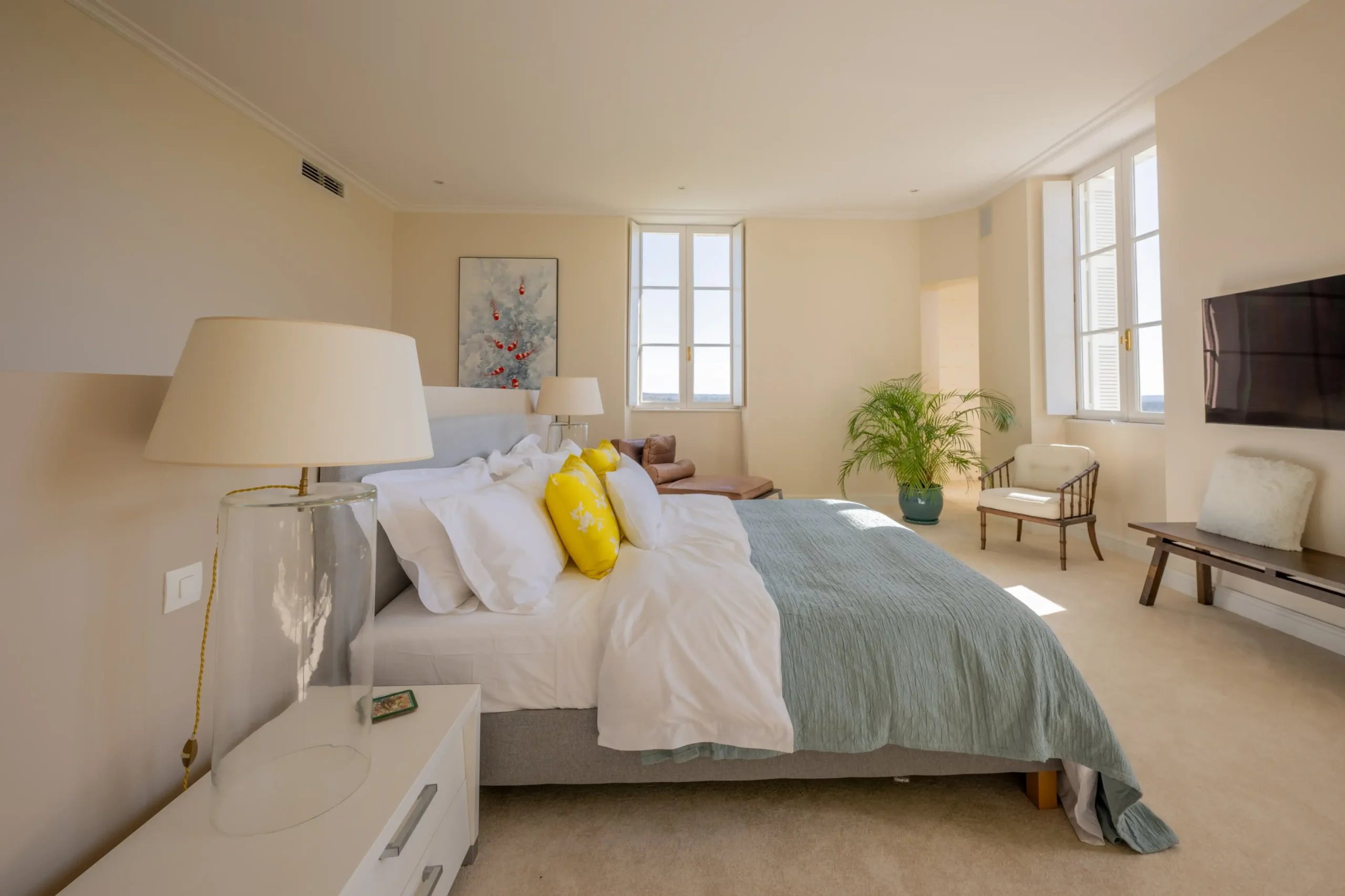 Master bedroom with king-sized bed, elegant decor, and natural light.
