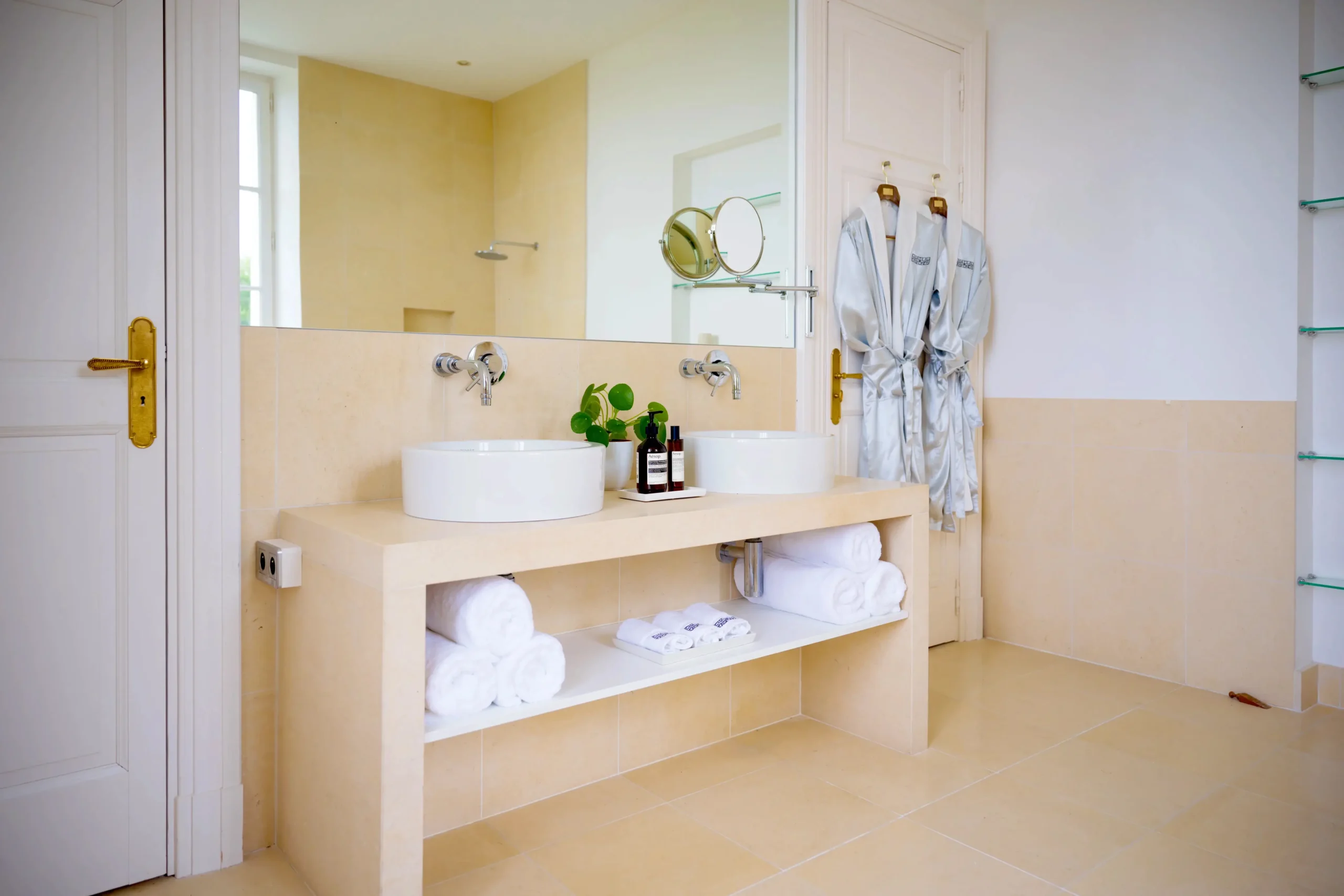 Modern bathroom with double sink, open shelves, and bright lighting