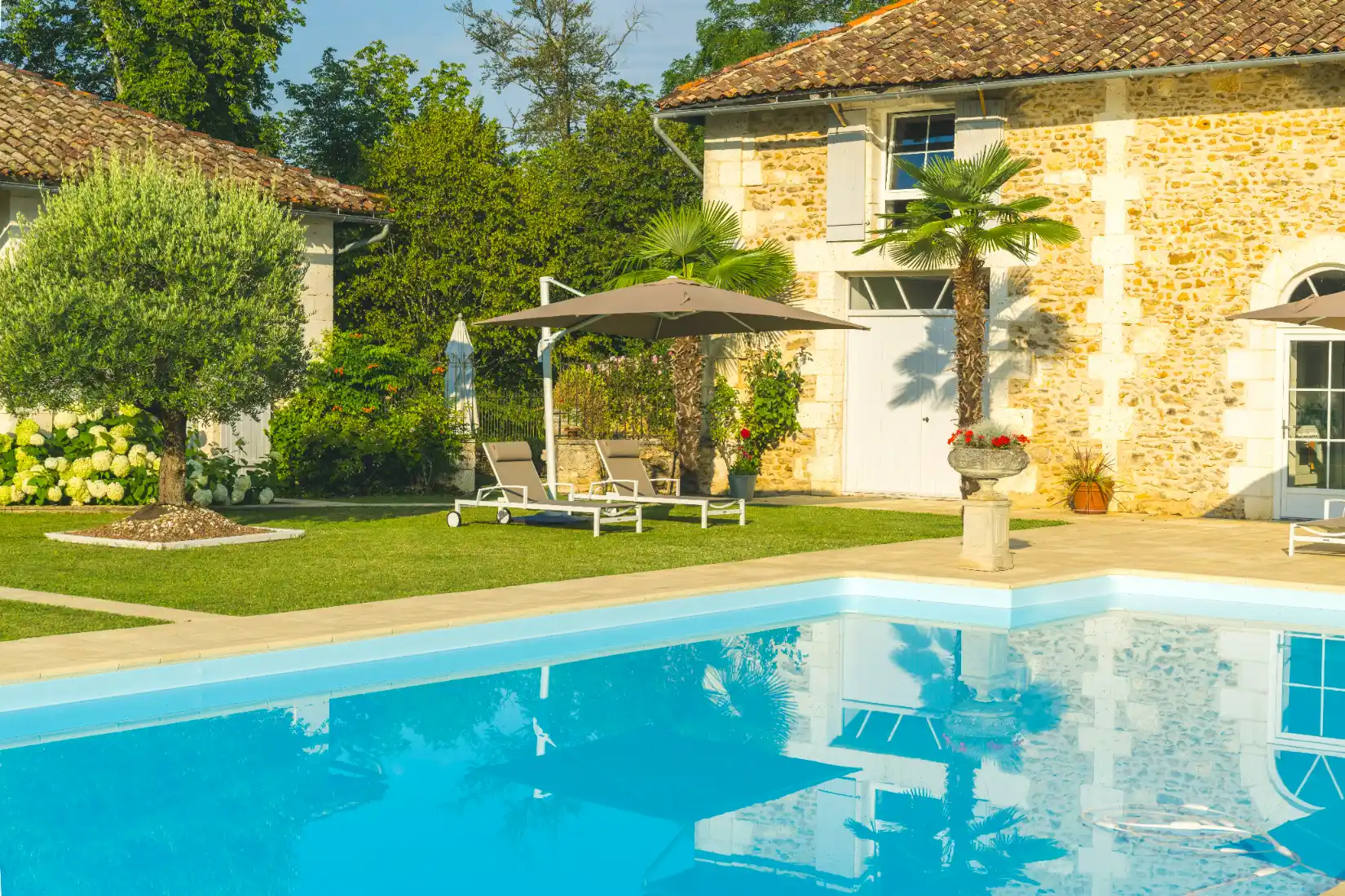 Luxury poolside retreat with a sun hat and drink on a towel