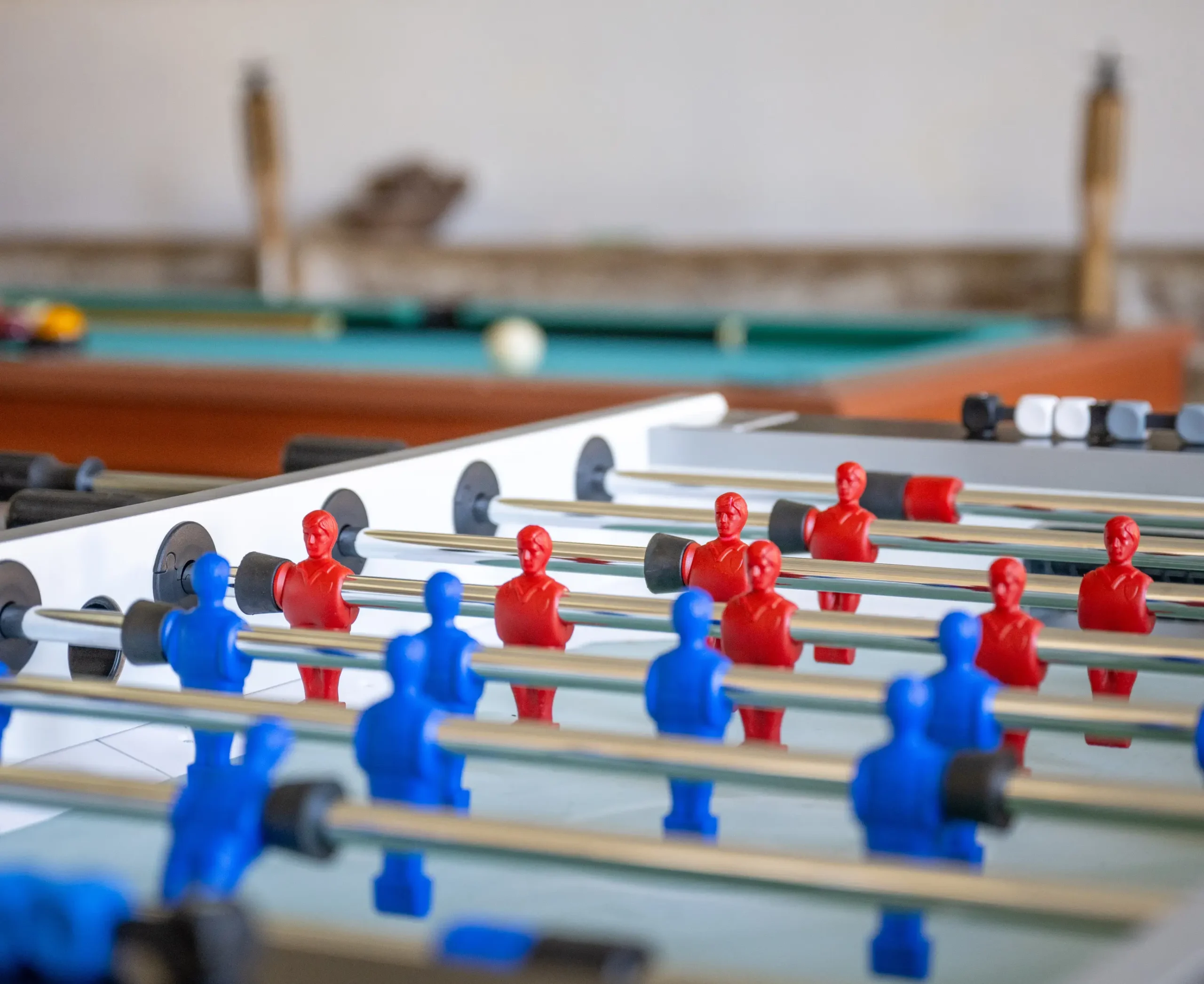 Foosball table with red and blue players in a games room