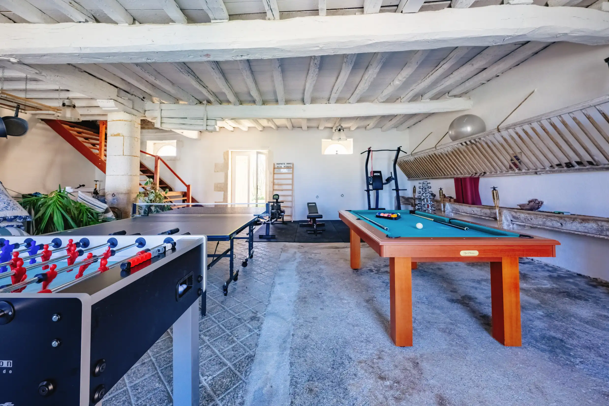 Games room featuring a mix of sports tables and exercise equipment