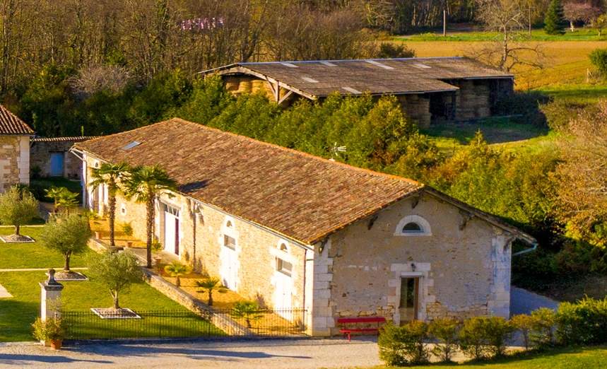 Stone house with a sloped roof and a garden view