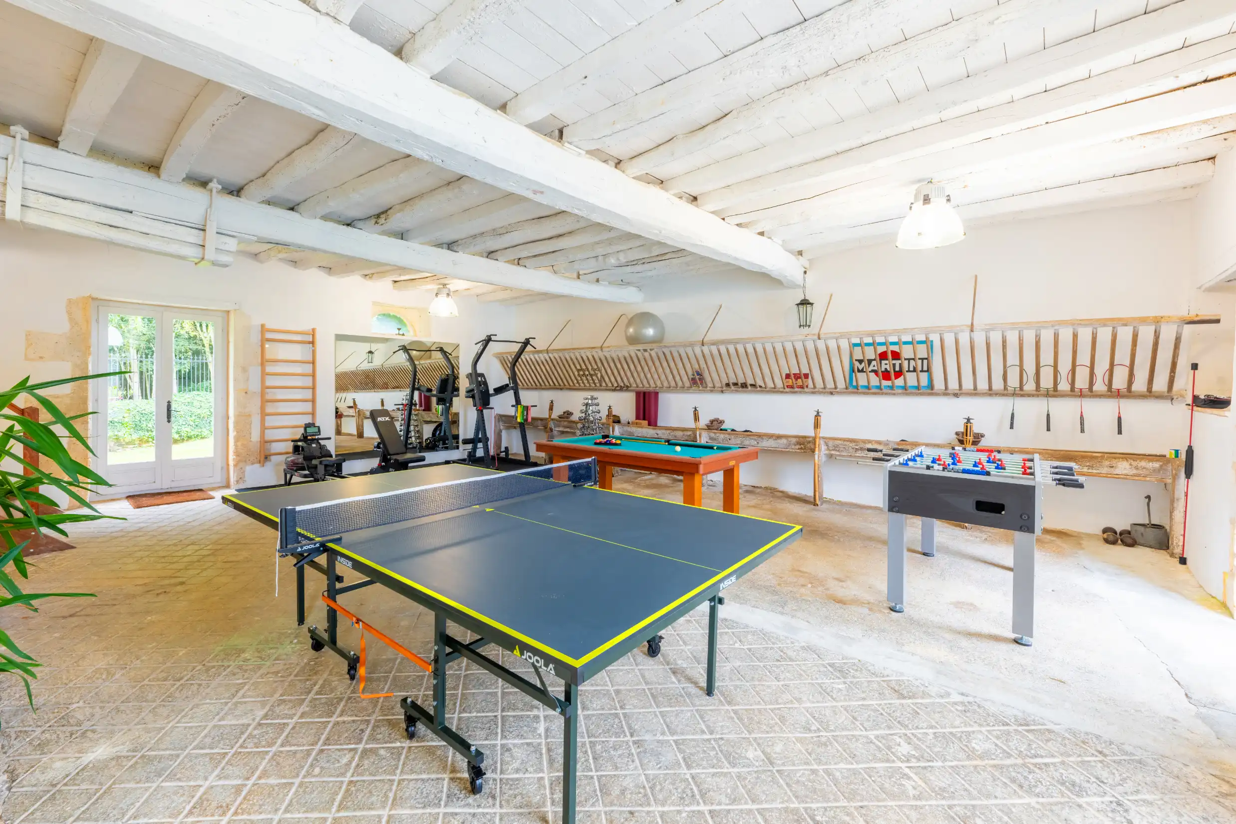 able tennis setup in a spacious games room with wooden beams and bright lighting