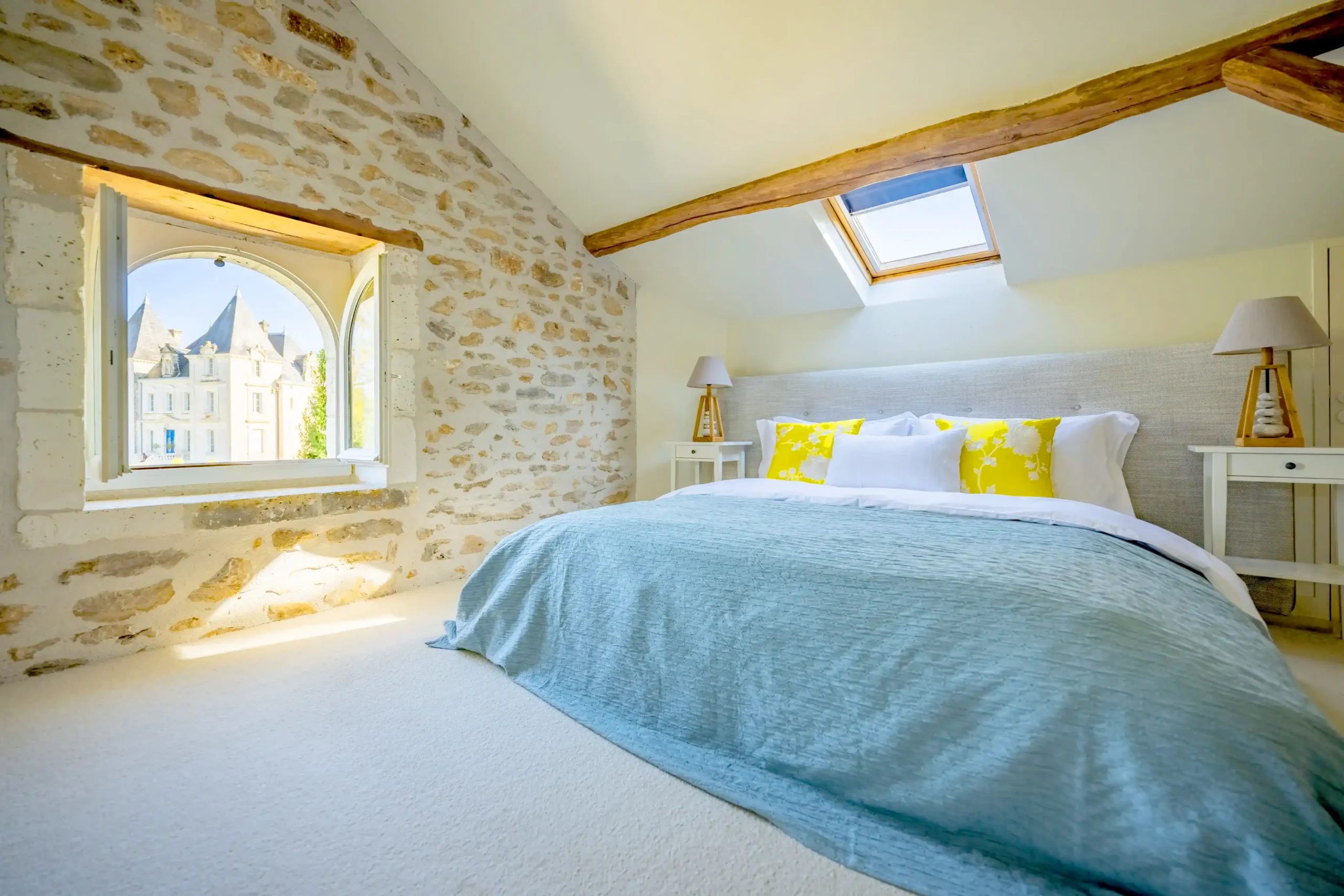 Cozy bedroom with skylight in a rustic stone cottage