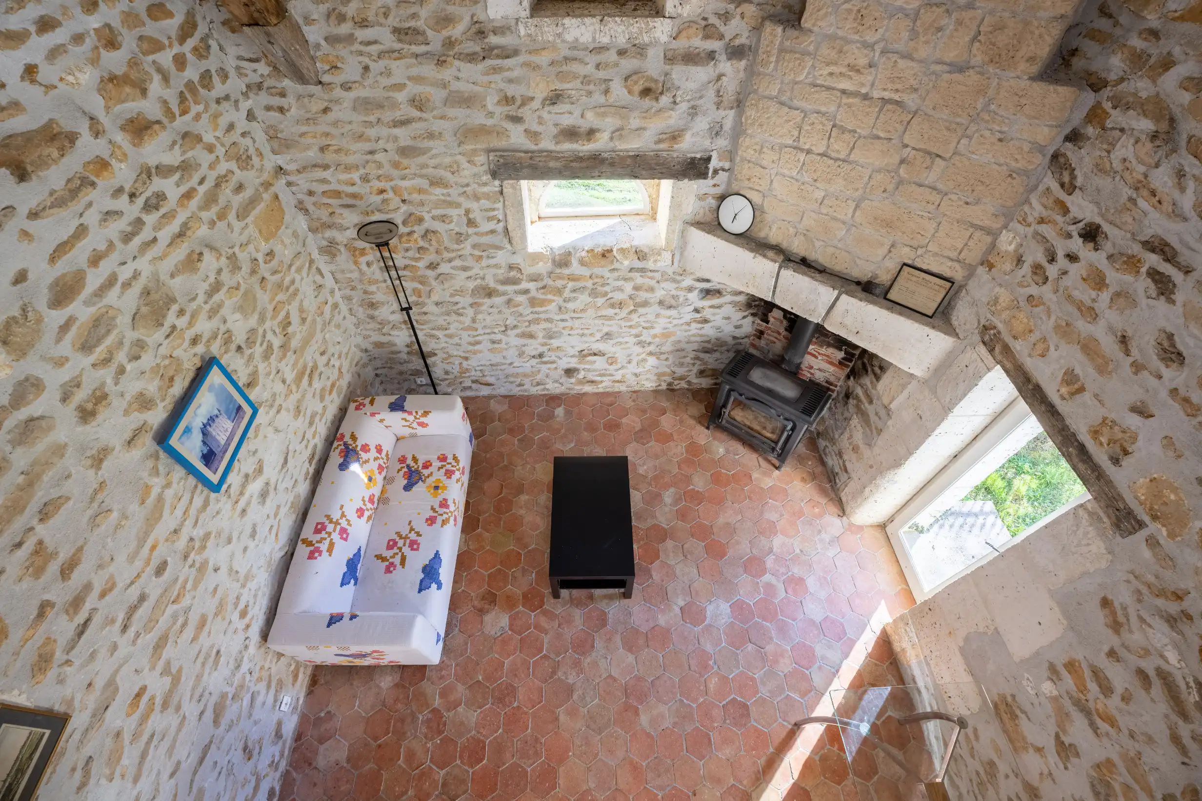 Cozy living space with sofa, pantry, and wood-fired oven in Loft Gite