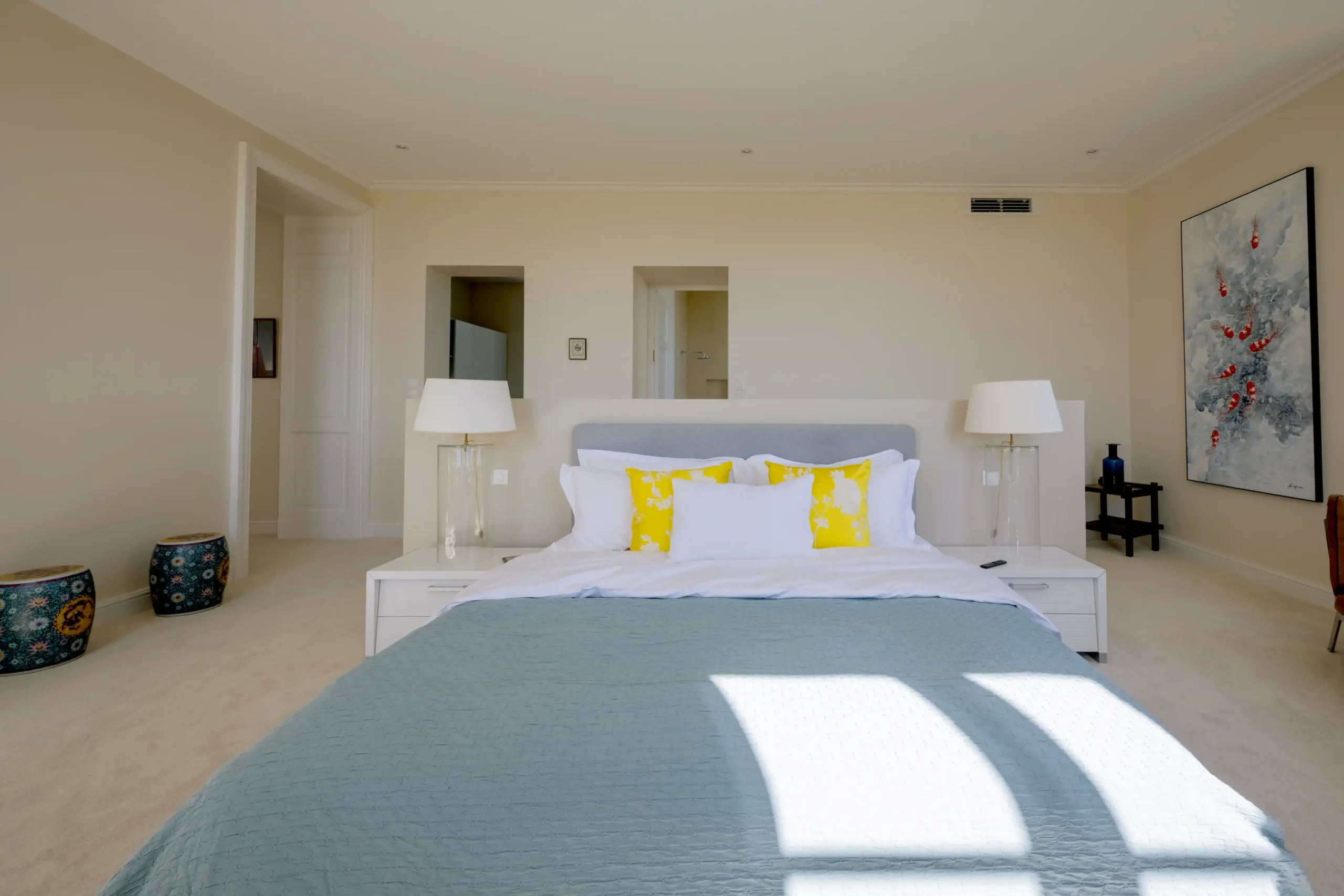 Spacious bedroom with a large bed, stylish decor, and soft lighting