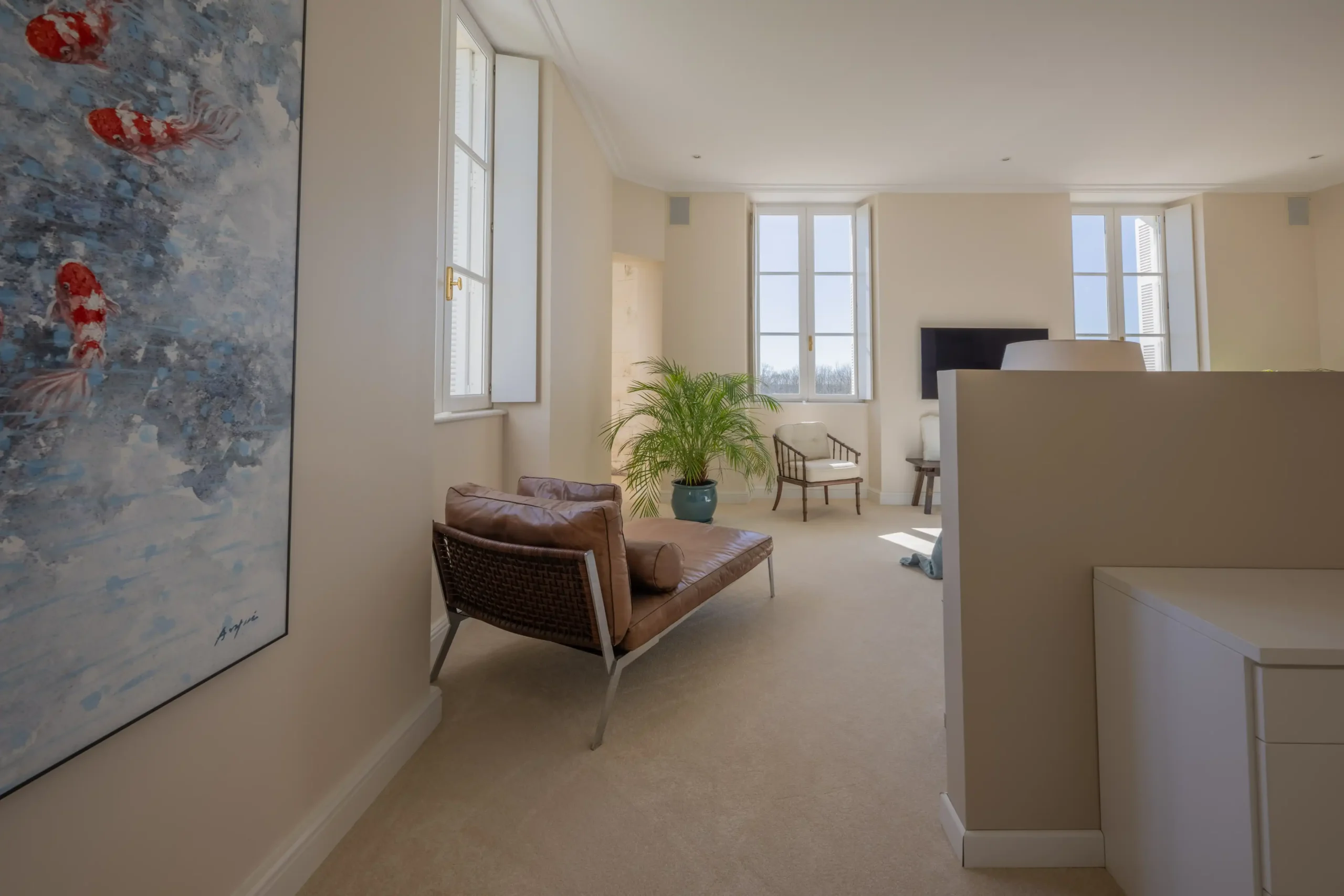 Cozy sitting area with chairs, a table, and large windows