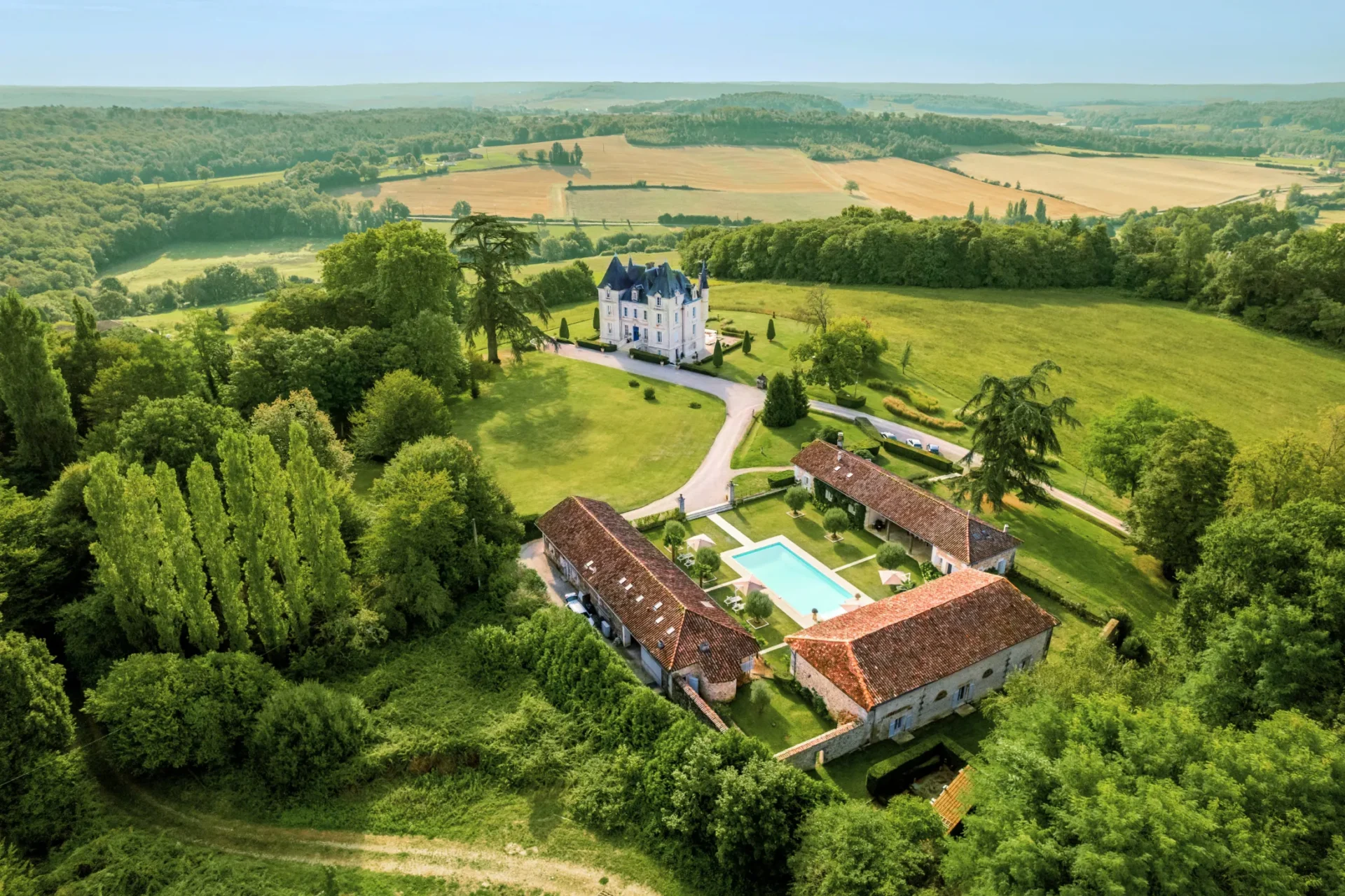 Aerial view of a château with a pool