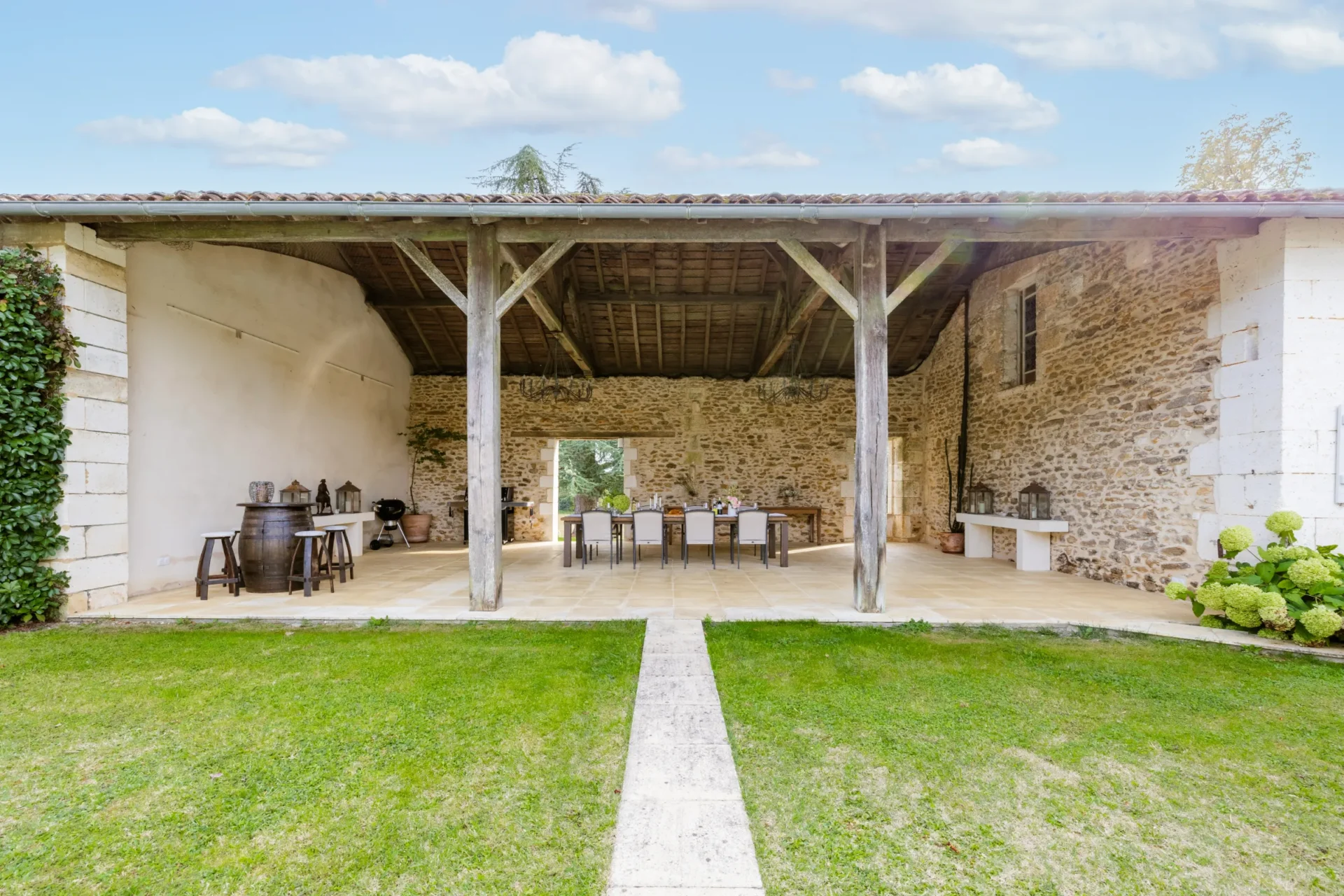 Covered outdoor dining area with wooden beams and stone walls