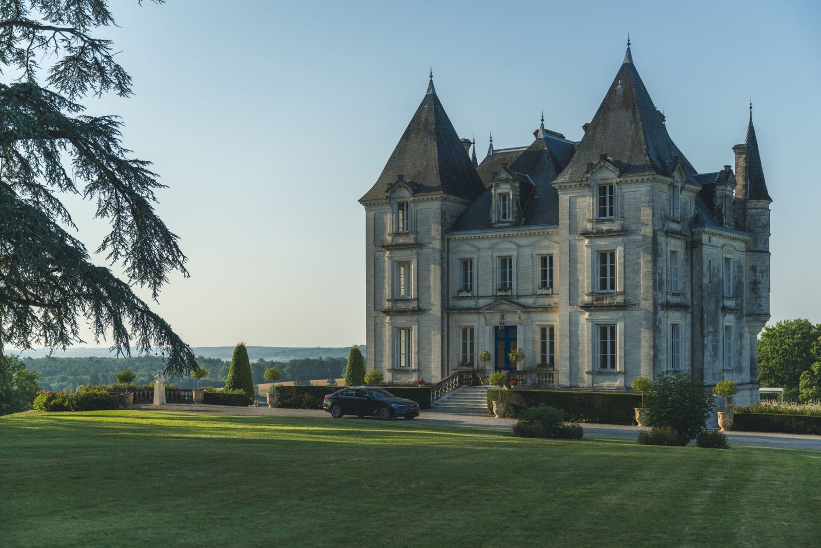 Front view of Château de Lasfonds with manicured lawns, illustrating what is a French château in its complete architectural elegance.